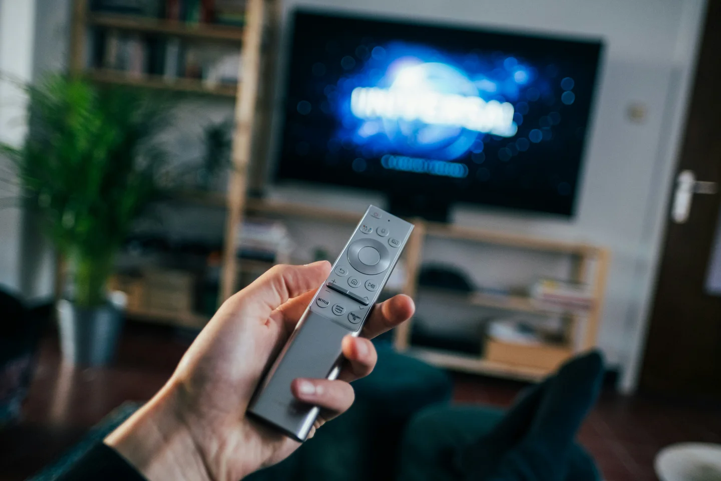 Une personne choisit un programme avec une télécommande